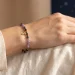 Kamień dla Strzelca: bransoletka z ametystem, obsydianem, szafirem i zawieszką znaku Strzelca na nadgarstku